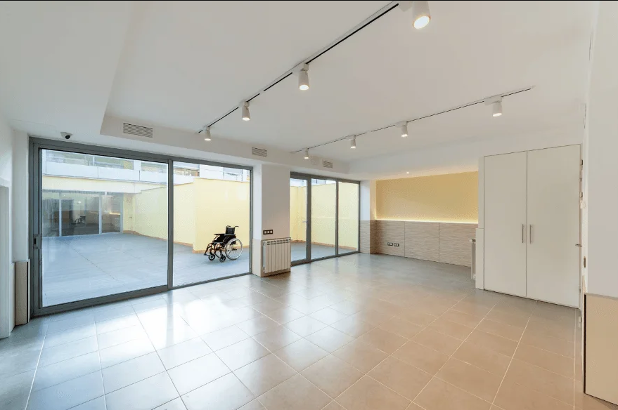 Sala accesible con rampa al exterior y silla de ruedas visible